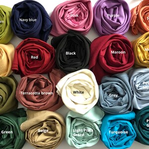 May include: A collection of 18 rolled fabric swatches in various colors, including lime green, navy blue, pink, purple, salmon, mustard, black, maroon, vanilla, red, powder blue, terracotta brown, white, olive green, grey, peacock green, dark green, beige, light pista green, and turquoise.