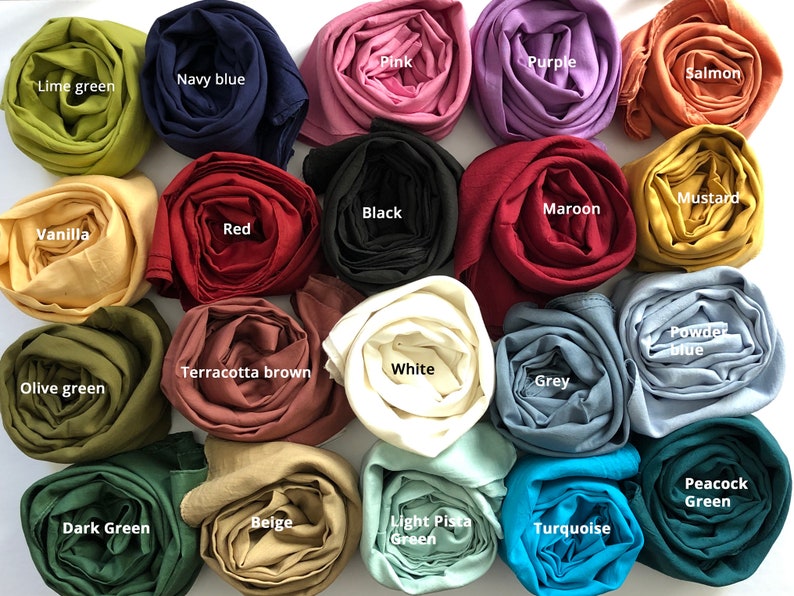 May include: A collection of 18 rolled fabric swatches in various colors, including lime green, navy blue, pink, purple, salmon, mustard, black, maroon, vanilla, red, powder blue, terracotta brown, white, olive green, grey, peacock green, dark green, beige, light pista green, and turquoise.