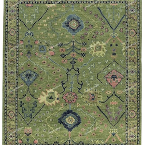 May include: A green rug with a traditional Persian design. The rug features intricate floral patterns in shades of pink, blue, and yellow.