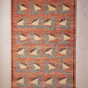 May include: A rectangular rug featuring a repeating pattern of cream-coloured sailboats with black accents, set against a rust-coloured background. The rug has a fringed border. The rug's design is reminiscent of nautical themes.