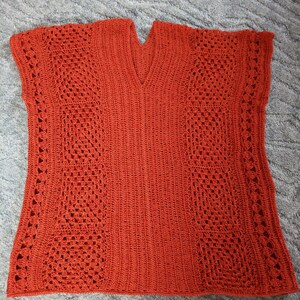 Może przedstawiać: Kr&oacute;tki sweterek wykonany na szydełku z dekoltem w kształcie litery V i bez rękaw&oacute;w. Sweterek jest wykonany z jasno pomarańczowej przędzy i ma ażurowy wz&oacute;r.