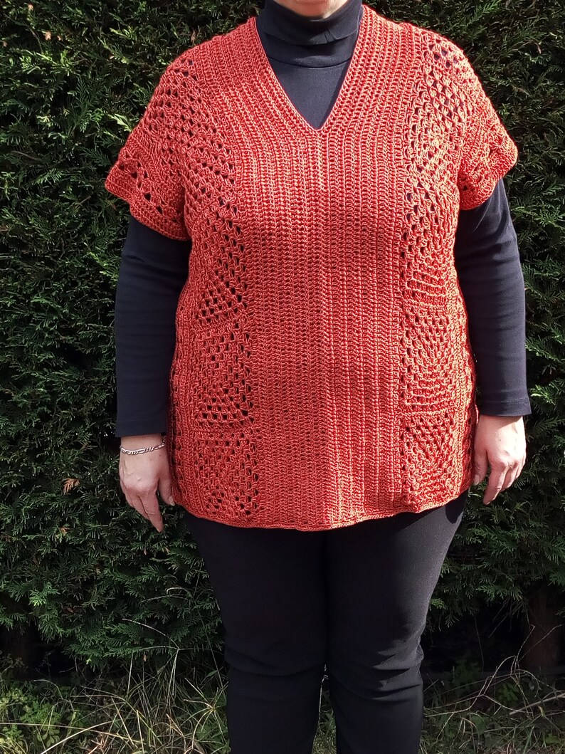 Może przedstawiać: Kr&oacute;tki top na szydełku z dekoltem w kształcie litery V i kr&oacute;tkimi rękawami. Top jest w kolorze rdzawo-pomarańczowym i ma koronkowy wz&oacute;r.