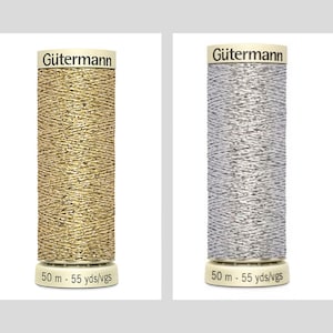 Könnte beinhalten: Zwei Spulen Gütermann-Garn, eine gold und eine silber, jede mit 50 Metern (55 Yards) Garn.