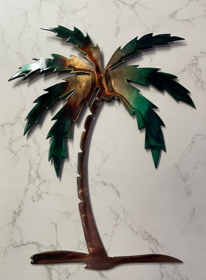 May include: A metal palm tree wall decor with a green and brown finish. The palm tree has a textured, rustic look.