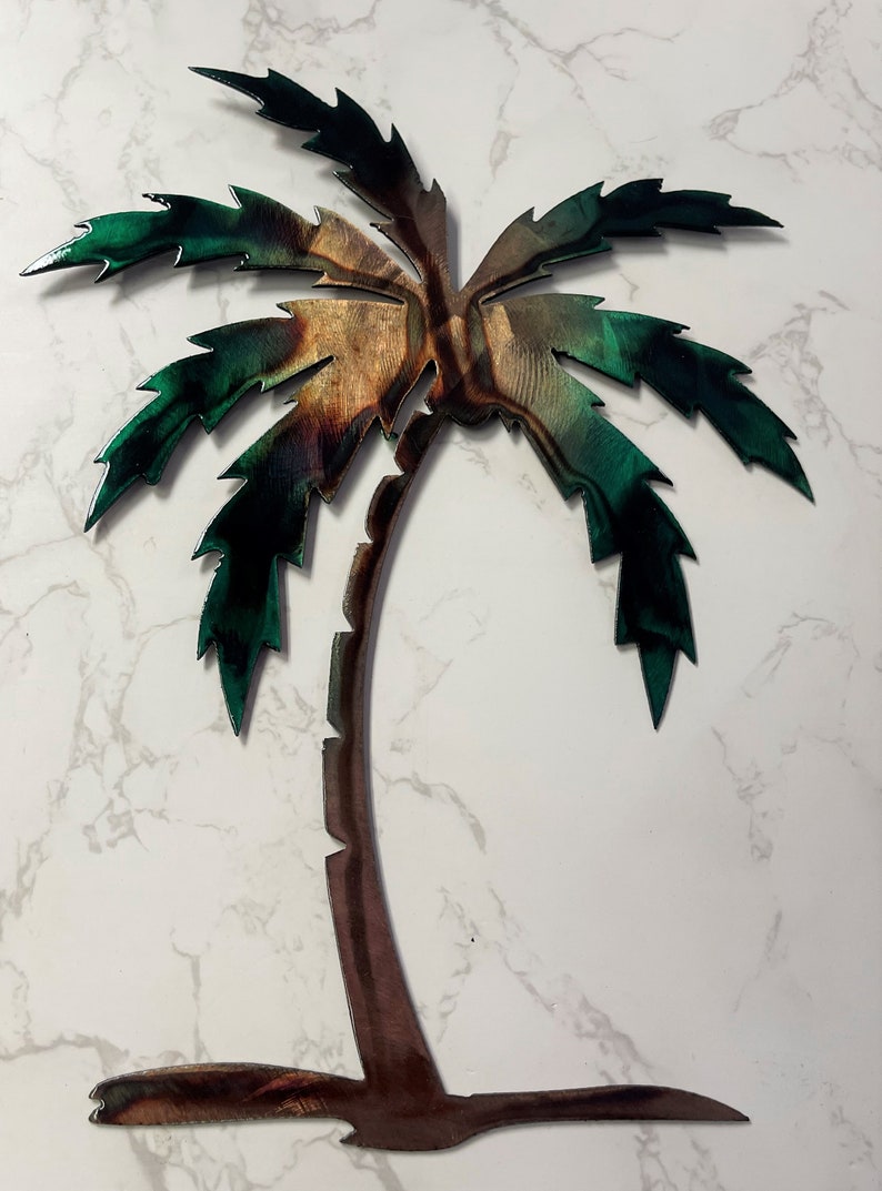 May include: A metal palm tree wall art with a brown trunk and green leaves. The leaves have a textured, metallic finish.