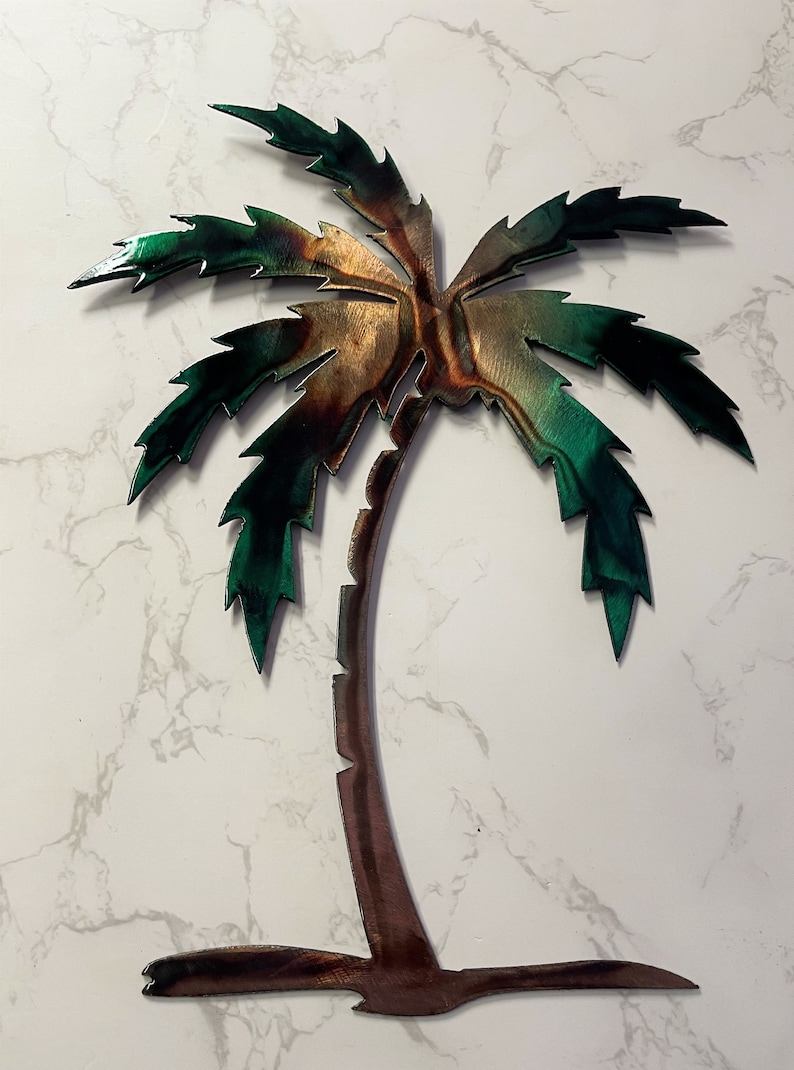 May include: A metal palm tree wall decor with a brown trunk and green leaves. The leaves have a metallic sheen and are textured.