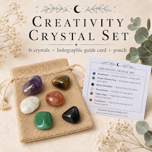 May include: A Creativity Crystal Set featuring six polished stones including amethyst, green aventurine, black obsidian, moonstone, tiger's eye, and carnelian. The set includes a tan burlap drawstring pouch and a white holographic guide card.