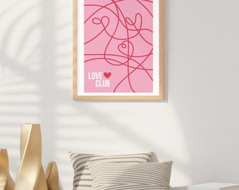 Può includere: Una stampa incorniciata con sfondo rosa e linee astratte rosse. Il testo "LOVE CLUB" è stampato in bianco con un simbolo di cuore rosso.