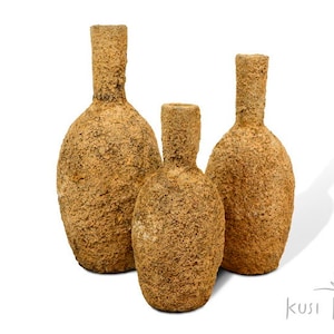 May include: Three terracotta vases of varying sizes with a rough, textured surface. The vases are arranged in a row from largest to smallest.