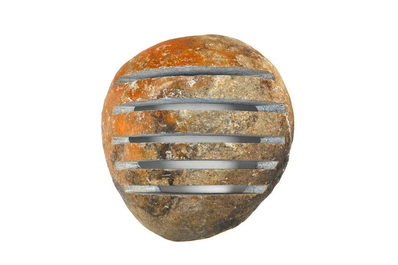 May include: A rounded, weathered stone with horizontal, evenly spaced grooves. The stone's surface displays a mix of orange, brown, and gray hues. The grooves appear to be filled with a lighter gray material, creating a contrast.