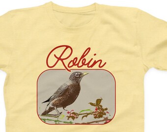 May include: A yellow t-shirt with a red graphic of a robin perched on a branch with berries. The text "Robin" is written in red cursive above the bird.