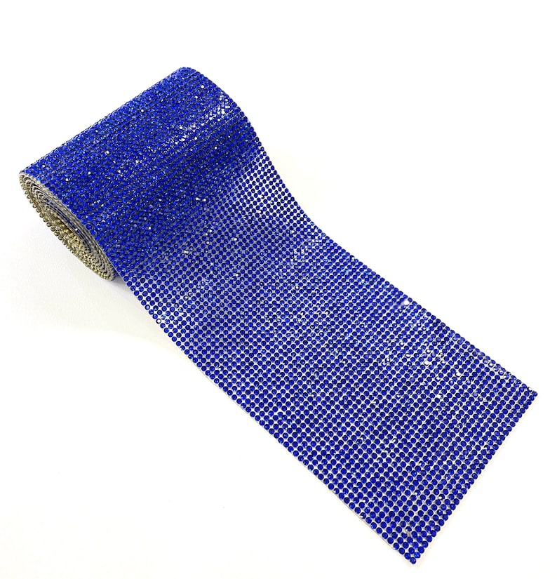 K&ouml;nnte beinhalten: Eine Rolle blauer Strassbesatz. Der Besatz besteht aus kleinen, runden Strasssteinen, die in einem Gittermuster angeordnet sind. Der Besatz ist aufgerollt und bereit f&uuml;r Bastelarbeiten oder Dekorationen.