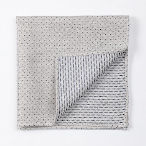 May include: A reversible gray and blue kitchen towel with a small dot pattern on one side and a thin stripe pattern on the other side.