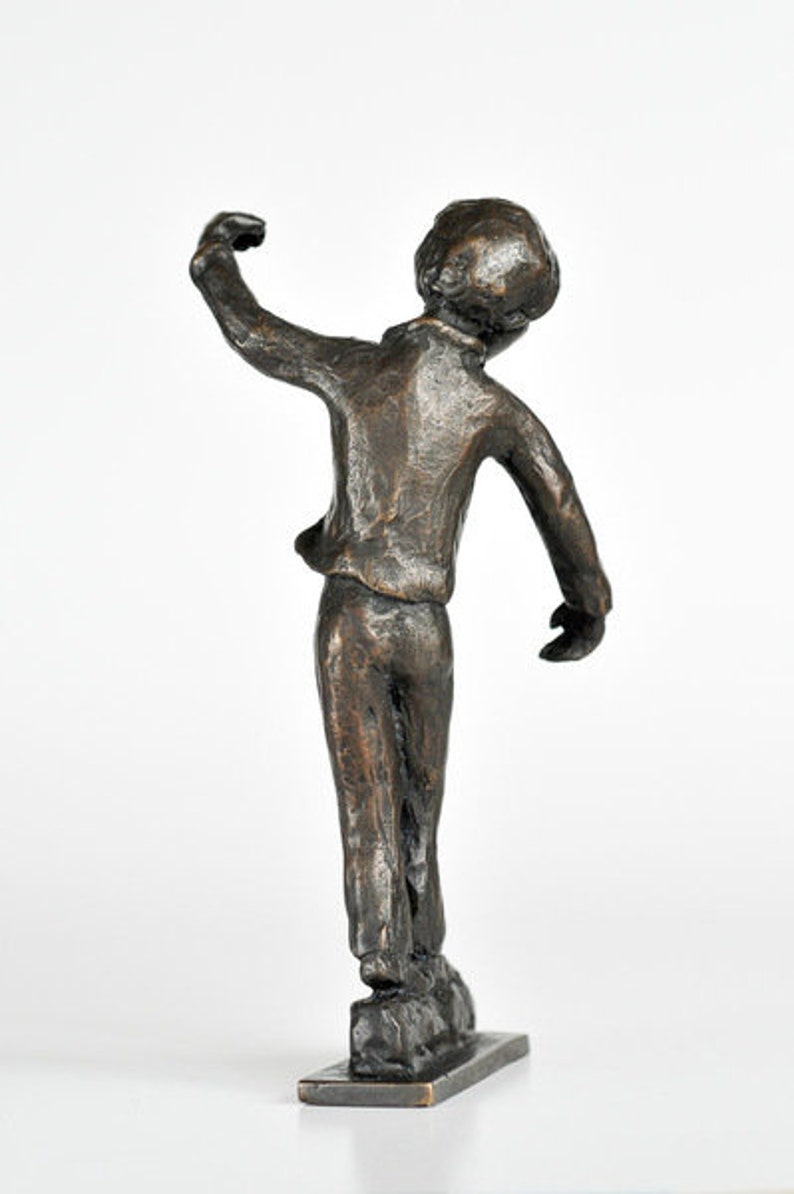 Junge balanciert Bronzeskulptur Bild 2