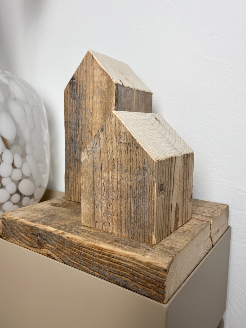 May include: Two wooden houses made from reclaimed wood, stacked on top of each other, on a wooden base.