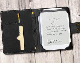 May include: A black leather case with a built-in e-reader. The e-reader screen displays the text "I am the very model of a modern major general I've information vegetable, animal and mineral GIZMODO".