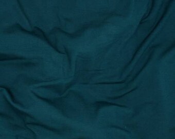 May include: A close-up of a teal blue fabric with a smooth texture and subtle wrinkles.