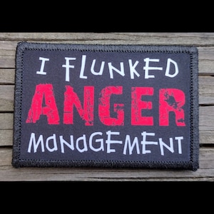 May include: Black patch with white stitching around the edges. The patch has white text that reads "I flunked anger management" with the word "anger" in red.