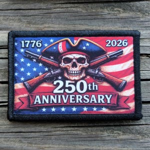 May include: Rectangular patch with a black border featuring a skull wearing a tricorn hat, crossed rifles, and the American flag. The text "1776" and "2026" flank the top, with "250th ANNIVERSARY" on a banner below.
