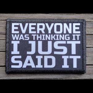 May include: A rectangular black patch with white text that reads "EVERYONE WAS THINKING IT I JUST SAID IT." The patch has a black stitched border and is set against a wooden background.