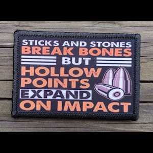 May include: A rectangular black patch with orange and white text that reads "STICKS AND STONES BREAK BONES BUT HOLLOW POINTS EXPAND ON IMPACT." The patch also features an illustration of three bullets.
