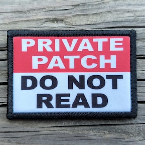 May include: A rectangular patch with a black border, featuring a red upper section and a white lower section. Bold white text reads "PRIVATE PATCH" above "DO NOT READ".