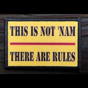 May include: A rectangular patch with a yellow background and black border. The text "THIS IS NOT 'NAM" is above a red horizontal line, and "THERE ARE RULES" is below it, all in black.
