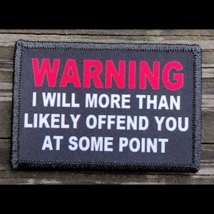 May include: A rectangular black patch with the word "WARNING" in red block letters at the top. Below, the text reads "I WILL MORE THAN LIKELY OFFEND YOU AT SOME POINT" in white block letters.
