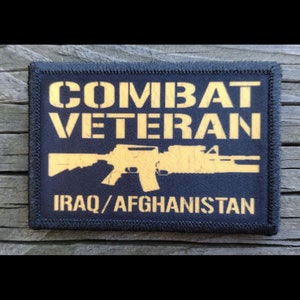 May include: Black patch with gold text that reads "Combat Veteran" and a silhouette of a rifle. Below the rifle is the text "Iraq/Afghanistan".