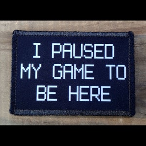 May include: Black patch with white text that reads "I PAUSED MY GAME TO BE HERE" in a pixelated font.