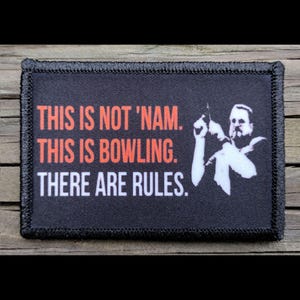 May include: Black rectangular patch with the text "THIS IS NOT 'NAM. THIS IS BOWLING. THERE ARE RULES." in orange and white. A white silhouette of a man bowling is on the right side. The patch has a black border.