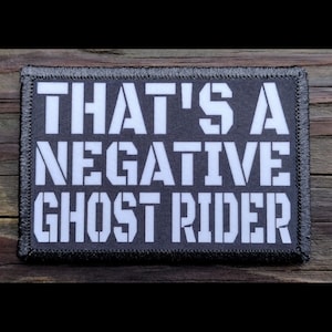May include: A black and white embroidered patch with the text "That's a Negative Ghost Rider" in white lettering.