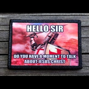 May include: A black and red embroidered patch with a knight holding a sword and shield. The text on the patch reads "Hello Sir Do You Have A Moment To Talk About Jesus Christ".