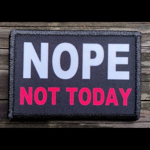 May include: A rectangular black patch with the word "NOPE" in large white capital letters above the words "NOT TODAY" in bright pink capital letters. The patch has a black border.