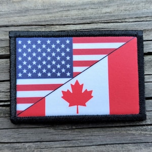 May include: Rectangular patch featuring a split design: the upper left displays the U.S. flag with stars and stripes, while the lower right shows the Canadian flag with a red maple leaf. The patch has a black border.