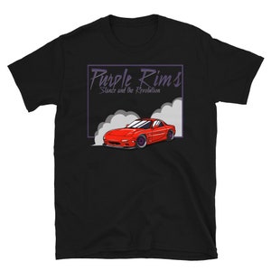 May include: Black t-shirt with a red sports car design, purple rims, and smoke effect. The text "Purple Rims Stance and the Revolution" is in a purple box. The shirt is made of a soft material. The design is a car enthusiast theme.