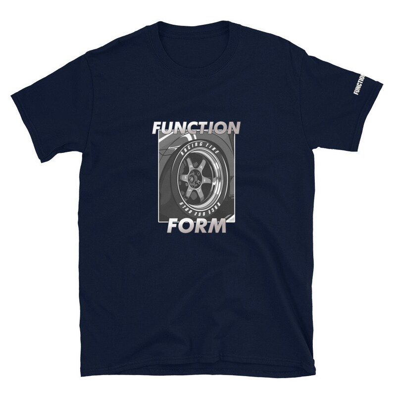 Op de afbeelding: Marineblauw T-shirt met korte mouwen met een afbeelding van een autowiel en de woorden "FUNCTION" en "FORM" in zilver. De mouw heeft het woord "FUNCTION" erop gedrukt. Het ontwerp staat in een rechthoekige lijst.