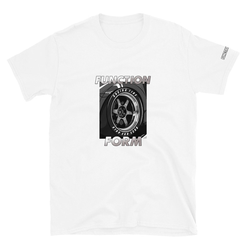 Op de afbeelding: Wit t-shirt met een zwart-wit afbeelding van een autowiel en de woorden "FUNCTION" en "FORM". De wielafbeelding bevat de woorden "RACING TIRE". Het woord "FUNCTION" staat ook op de mouw. Het t-shirt is gemaakt van zacht materiaal.