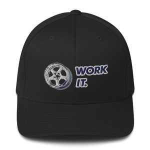 May include: Black baseball cap with a white rimmed wheel and the text "WORK IT." embroidered in blue.