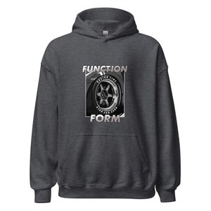 May include: A dark gray hooded sweatshirt with the text "FUNCTION FORM" printed in white. The graphic features a black and white illustration of a car wheel with the text "Racing Tire" printed on the tire.