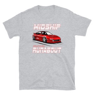 May include: A light grey t-shirt with a red sports car graphic. The car is illustrated with the text "MIDSHIP" above and "RUNABOUT" below. The shirt is made of a soft material. The car is a low-profile design.