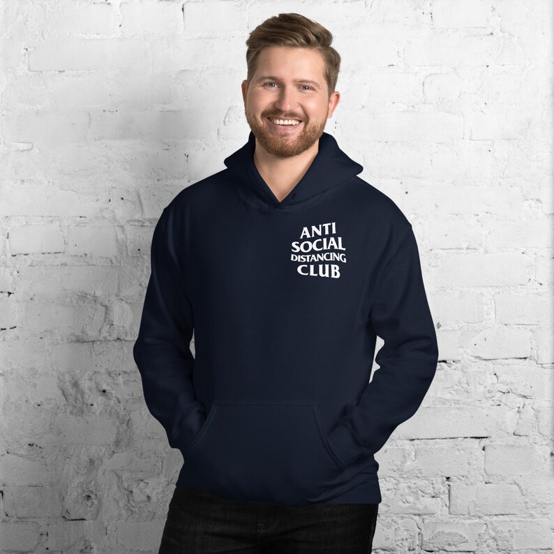 Peut inclure: Sweat-shirt &agrave; capuche bleu marine avec le texte blanc &laquo; ANTI SOCIAL DISTANCING CLUB &raquo;. Le sweat-shirt a une poche avant et une capuche &agrave; cordon. Le mod&egrave;le porte le sweat-shirt.