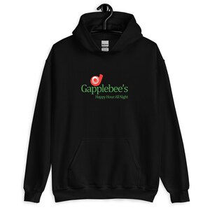 May include: Black hooded sweatshirt featuring the text "Gapplebee's Happy Hour All Night" in green and red. The sweatshirt has a front pocket and a drawstring hood. The brand name is printed in a stylized font.