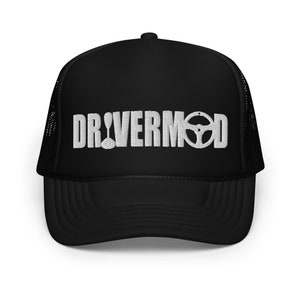 May include: Black trucker hat with white embroidered "DRIVERMOD" text, including a gear shift and steering wheel. The hat has a mesh back and a curved peak. A fashionable accessory for car lovers.