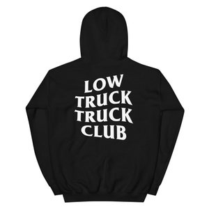 May include: Black hoodie with the white text "LOW TRUCK TRUCK CLUB" on the back. The hooded sweatshirt features a drawstring and a front pocket. The material appears to be soft and comfortable.