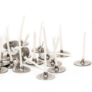 May include: A pile of silver candle wicks with white cotton threads. The wicks have a metal base.