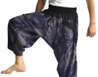Puede incluir: Un pantalón azul y gris con estampado y cintura negra. El pantalón tiene un corte holgado y fluido y presenta un diseño de peces koi y olas.