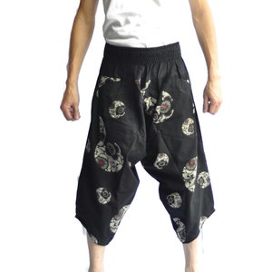 May include: Black pants with a white skull pattern. The pants have an elastic waistband and a loose fit.