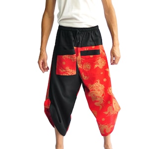 May include: Black and red patterned pants with a drawstring waist. The pants feature a dragon design in gold on a red background. The pants have two pockets and a loose, comfortable fit.