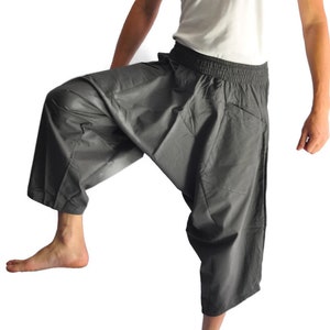 May include: Gray cotton pants with a wide leg and a drawstring waist. The pants are cropped and have a relaxed fit.